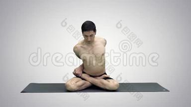 运动的美丽的年轻人练习<strong>瑜伽</strong>，<strong>盘腿坐</strong>在AdhoMukhaPadmasana，弯曲前进的变化
